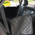 Black waterproof pet car seat cover installed in the back seat of a car